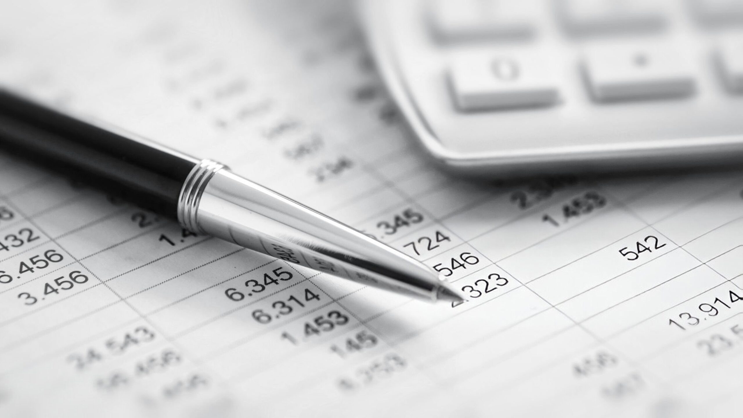 Five people in a modern office, smiling and collaborating around a laptop on a table.